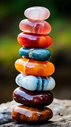 a stack of colorful rocks sitting on top of a rock covered in watermelon