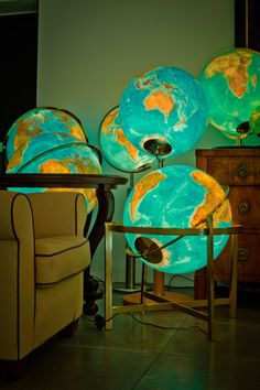 several globes sitting on top of a table next to a chair