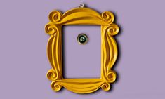 an ornate yellow frame with a green button on the front is shown against a purple background