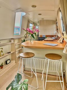 two stools are sitting at the bar in this small kitchen with an open window