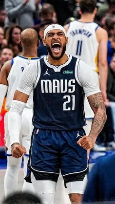 a basketball player with his mouth wide open in front of the other players and fans