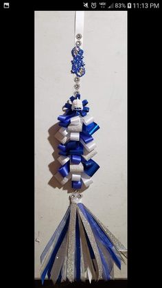 a blue and white ribbon ornament hanging from a hook on a wall in a room