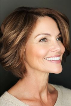 Short Wavy Bob Hairstyle on a smiling woman in her 50s with short brown hair with subtle highlights, side view.