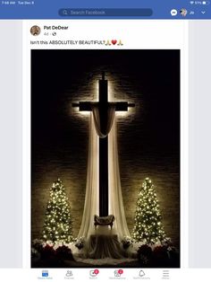 an image of a cross with christmas trees around it and lights on the wall behind it