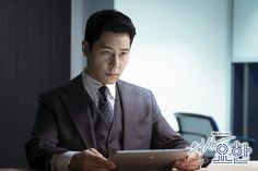 a man sitting at a table holding a tablet