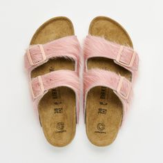 a pair of pink sandals with fur on the bottom and one foot in the middle