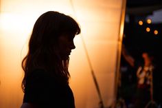 a woman standing in front of a white light