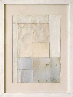 an abstract painting with white and grey squares on it's surface, framed in a white frame