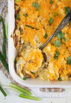 a casserole dish with green onions and cheese