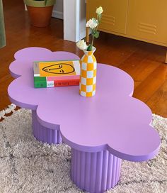 a flower vase sitting on top of a purple table