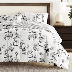 a bed with white and black flowers on it