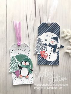 two tags with snowman and penguin on them