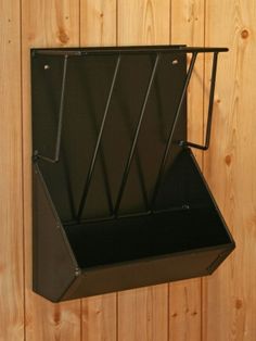 a black box hanging from the side of a wooden wall with metal bars attached to it