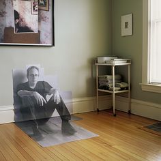 a photo of a man sitting on the floor in front of a table and chair