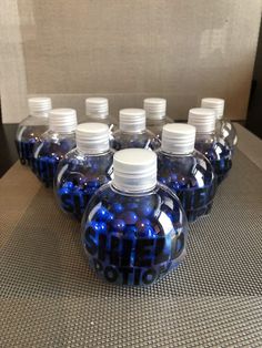 six blue glass bottles with white caps sitting on a table