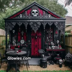 a black and red halloween shed with skulls on the front door, tables and chairs