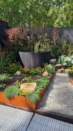 a garden with lots of different types of plants and rocks in the middle of it