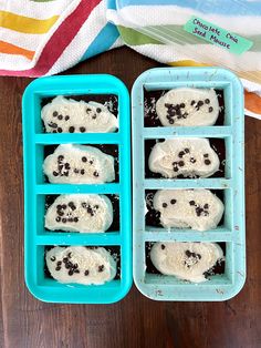 two trays filled with ice cream and chocolate chip cookies on top of a wooden table