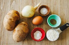 an assortment of ingredients on a table including potatoes, eggs, flour and seasoning