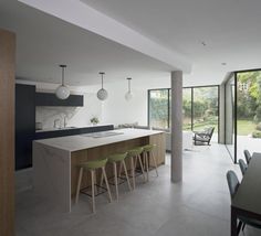 an open kitchen and dining area with bar stools in front of the countertop