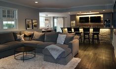 a living room filled with furniture next to a bar