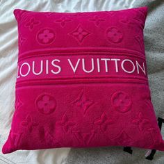 a pink pillow with louis vuitton on it