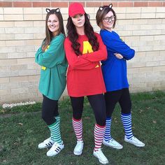 three women dressed in costumes standing next to each other with their arms around one another