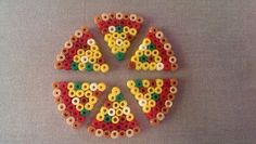 four pieces of colorful beads arranged in the shape of letters