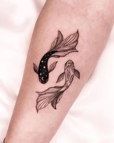 a black and white photo of a fish tattoo on the leg