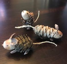 two pine cone shaped animals sitting on top of a wooden table