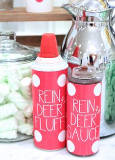 two red soda cans sitting on top of a counter next to other candy and candies