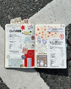 an open book with stickers on it laying on the ground