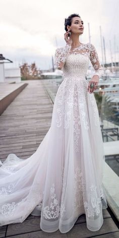 a woman in a wedding dress standing on a dock