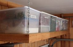 several plastic containers are hanging from the ceiling in a room with wood paneled walls