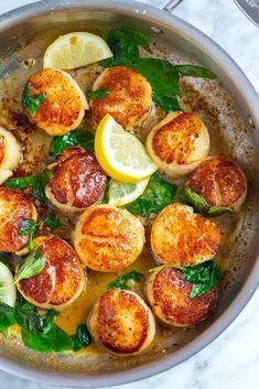 cooked scallops with spinach and lemon in a pan