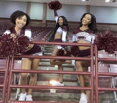 three cheerleaders posing in the bleachers