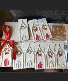 six handmade christmas cards with red bows and bells on them, sitting on a table