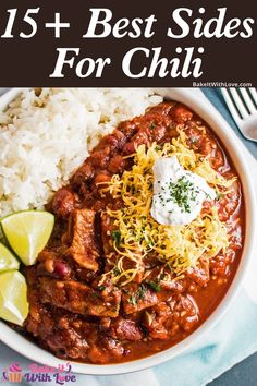 a white bowl filled with chili and rice next to a fork, knife and spoon