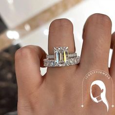 a woman's hand with an engagement ring and two diamond rings on top of it