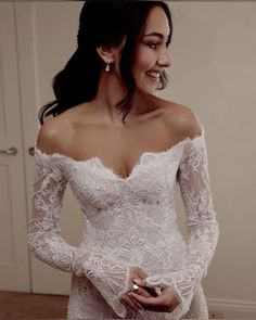 a woman in a wedding dress is smiling