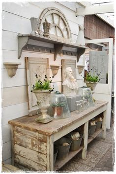 an old wooden table with pots and plants on it