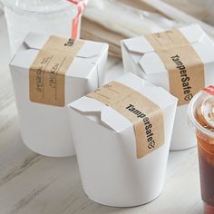 three cups with drinks in them sitting next to each other on a table, one is empty and the other has brown paper wrapped around it