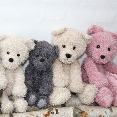 five stuffed teddy bears are lined up in a row on top of a piece of fabric