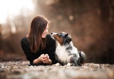 a woman sitting on the ground with her dog