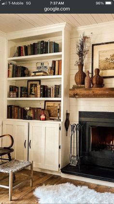 a living room filled with furniture and a fire place in front of a book shelf