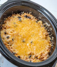 a crock pot filled with cheese and black beans