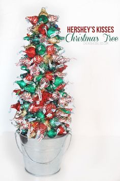 there is a christmas tree made out of candy in a bucket with the words hersey's kisses on it