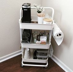 a white cart filled with items on top of a hard wood floor