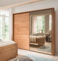 a bedroom with a bed, dresser and mirror on the wall in front of it