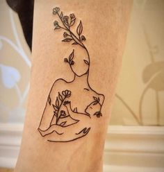 a woman's leg with a tattoo on it that has flowers growing out of her body